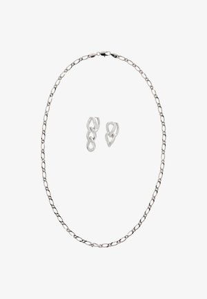 Srebrny naszyjnik z łańcuszkiem o wydłużonych owalnych ogniwach i zapięciem; towarzyszące kolczyki mają splecione pętle z połyskującym wykończeniem.