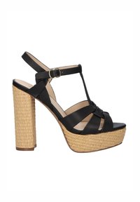 Sandalias de plataforma de cuero negro con un tacón de paja tejido, que presenta un diseño de barra en T y una correa ajustable en el tobillo. Textura de cuero suave.