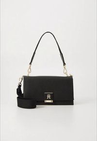 Czarna skórzana torebka o teksturowanej powierzchni, z złotymi okuciami, przednim zapięciem i odpinanym paskiem na ramię.