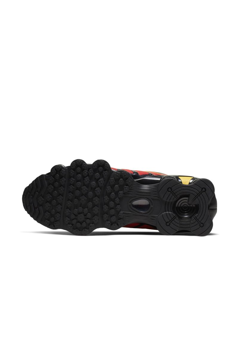 Semelle de chaussure de sport noire avec un motif texturé. Présente des accents multicolores et une section ronde distinctive au talon.