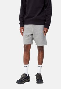 Gray cotton shorts with side pockets, paired with a black sweatshirt. Worn with black hiking shoes and white crew socks featuring black text.
