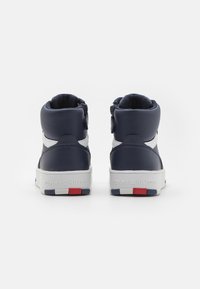 Marina hög-top sneakers med vita detaljer, vadderad krage och gummisula. Har en logotyp på hälen och en mönstrad yttersula.