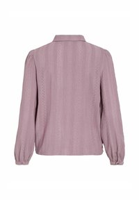 Lyse lilla langermet bluse med krage, teksturert stoff, vertikale striper og dekorative hullet detaljer langs sømmene.