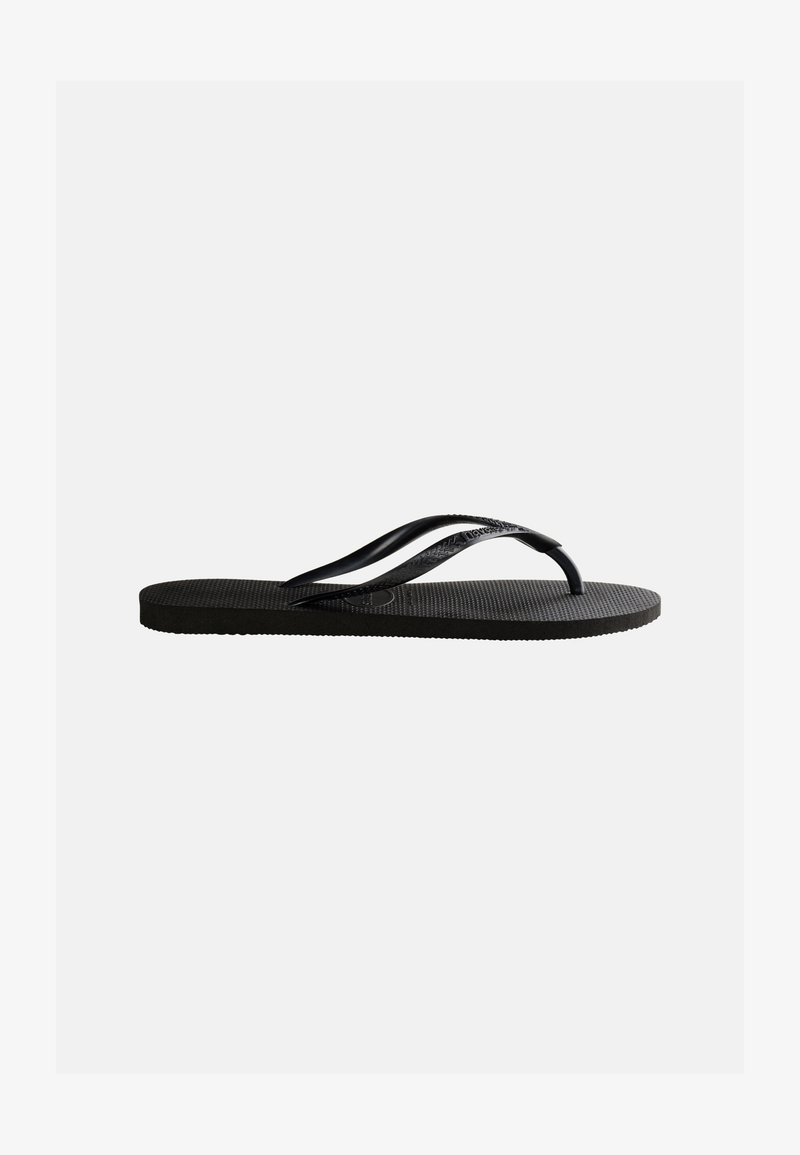 Chancla negra de goma con plantilla texturizada y finas correas en forma de Y sobre un fondo blanco liso.