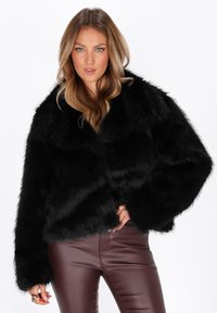 Sort faux fur jakke med bred krave, løs pasform og voluminøse ærmer. Glat tekstur og let cropped design.