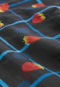 Material cu model care prezintă căpșuni roșii cu accente galbene și forme ovale albastre pe un fundal negru, evidențiind o textură netedă.