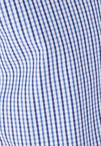 Tessuto di cotone con un motivo a quadri blu e bianchi, caratterizzato da righe strette e larghe di diverse tonalità di blu.