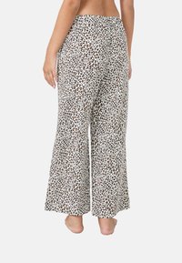 Pantaloni a gamba larga con stampa leopardata, texture morbida, base bianca e macchie marroni. Fascia elastica in vita e design a taglio dritto.