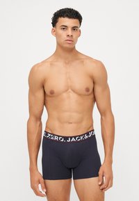Dunkelblaue Boxershorts mit einem schmalen Bund, der weißen Text trägt. Hergestellt aus einem glatten Stoff, verfügen sie über eine enganliegende Passform und gestickte Details.