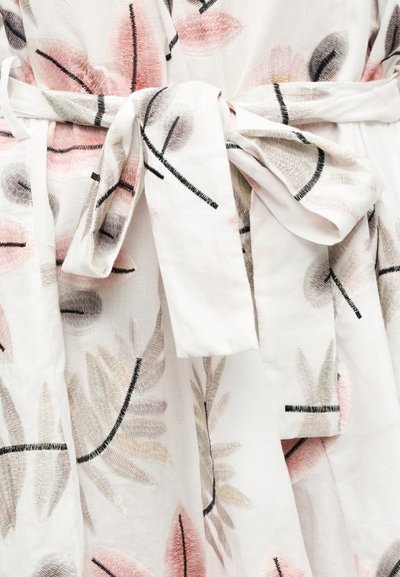 Λευκό ύφασμα με ροζ, πράσινη και γκρι κεντητική με λουλούδια. Διαθέτει δετή μέση και ρέουσα σχεδίαση. Απαλή υφή και λεπτομερείς ραφές.