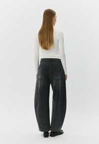 Visoko pasene črne denim hlače sproščenega kroja, z izblitjem, štirimi žepi in ravnim krojem.