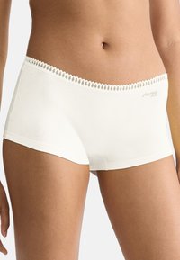 Hipstertrusser i cremefarvet blødt bomuld med tekstureret blondekant og en lille logo på venstre side.