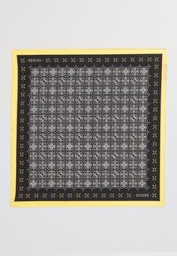 Foulard carré noir et jaune avec des motifs géométriques complexes en blanc et rose, bordé d'une bordure jaune solide.