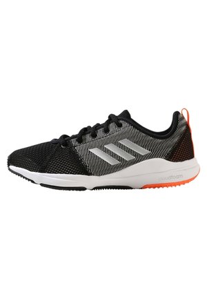 Zwarte en grijze Adidas sportschoen met witte zool, oranje accenten op de buitenzool en drie reflecterende strepen aan de zijkant.
