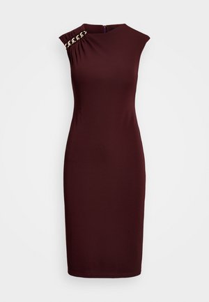 Robe ajustée sans manches, longueur genou, de couleur bordeaux foncé avec un décolleté asymétrique et un détail chaîne dorée sur une épaule.
