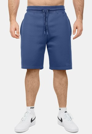 Shorts de sport bleus en tissu doux, avec une taille à cordon ajustable, des poches latérales et une finition ourlée.