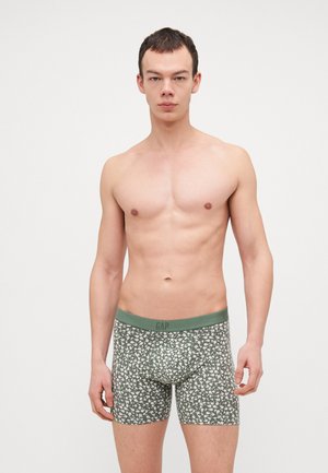 Boxeri scurți cu model floral verde, cu un chingi asortat. Fabricat dintr-un material moale, cu o formă ajustată și o ușoară elasticitate.