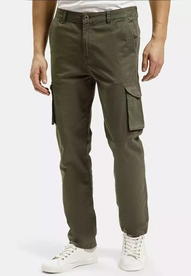 Olive zielone spodnie cargo wykonane z bawełny, z bocznymi kieszeniami, prostym krojem i zapięciem na guzik, w połączeniu z białymi trampkami.