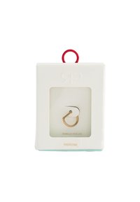 Złocona stal nierdzewna, kolczyk w kształcie kółka, w przezroczystym pudełku z czerwoną pętelką do zawieszenia. Etykieta produktu jest oznaczona "Stal nierdzewna 316".