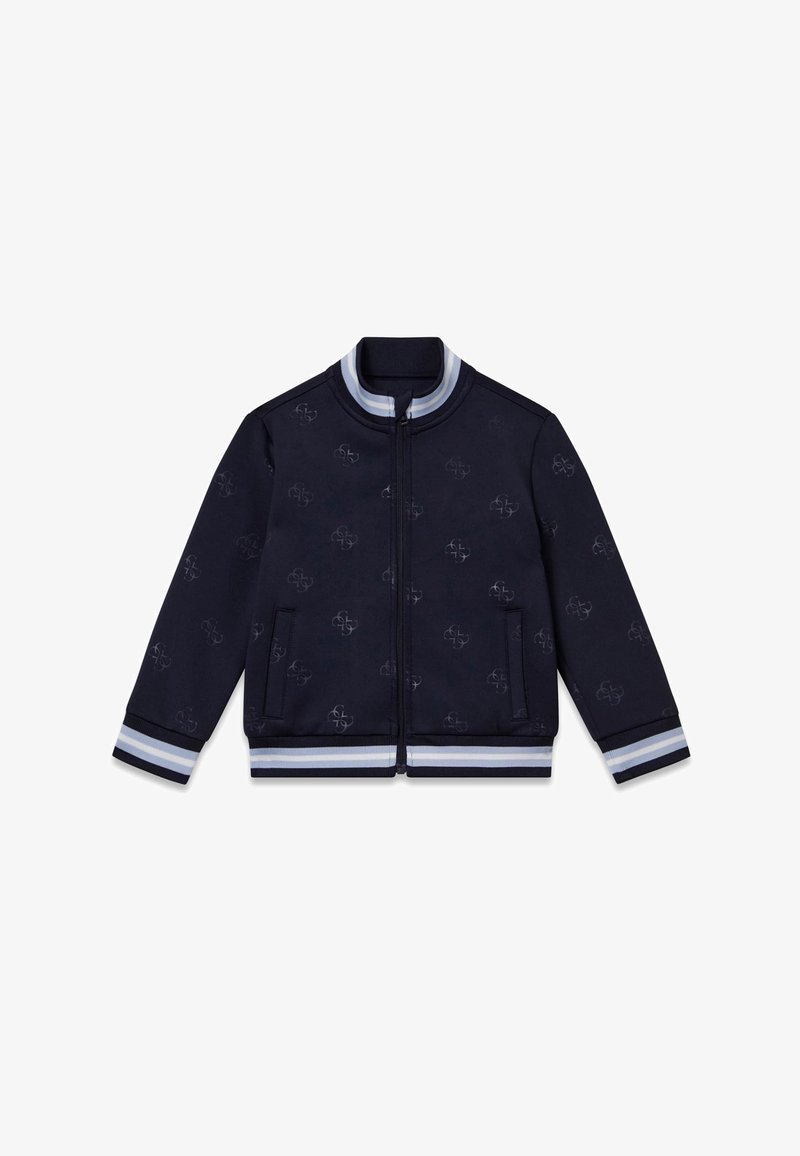 Veste bleu marine avec fermeture éclair à l'avant, présentant un motif discret en relief. Poignets et ourlet côtelés avec des rayures grises et blanches. Deux poches latérales.