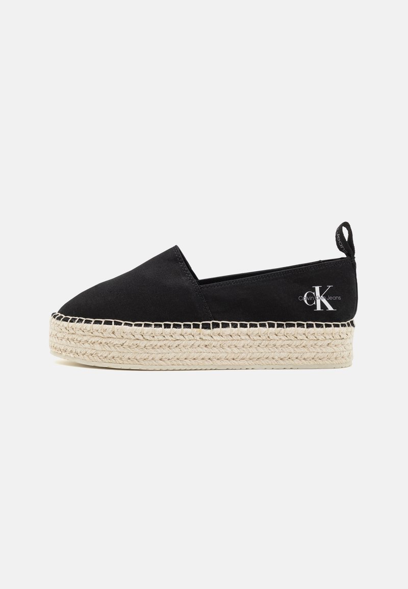 Espadrille noire à enfiler avec semelle épaisse en jute tressé et logo Calvin Klein Jeans sur l'onglet du talon, vue latérale sur fond blanc.