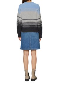 Gestreifter Strickpullover in Blau, Grau und Schwarz, kombiniert mit einem Denim-Rock. Kurze Ärmel, gerippter Kragen und normale Passform. Stiefel bis zur Mitte der Wade.
