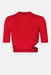 Top recortado rojo hecho de una tela suave, con un cuello alto y mangas cortas, y una banda de logo negra en la parte inferior.