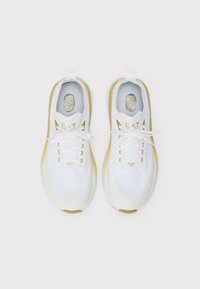 Hvite sneakers med gullakenter, mesh-overdel, snøring og logo-detaljer. Rund tå og lett såle-design.
