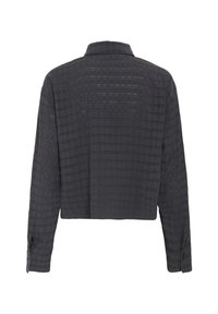 Gekürzte schwarze Hemdbluse aus strukturiertem Stoff mit Rautenmuster. Sie hat lange Ärmel und einen klassischen Kragen mit geknöpften Manschetten.