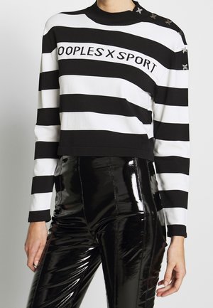 Černo-bílé horizontálně pruhované tričko s dlouhým rukávem s potiskem "PEOPLES X SPORT" a hvězdičkovými detaily na rameni, doplněné lesklými černými kalhotami.