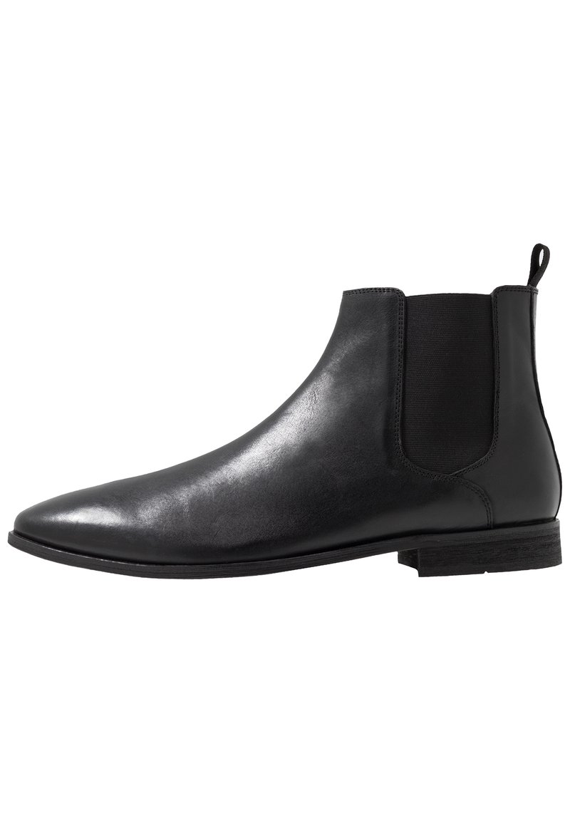 Svart läder Chelsea-boot med elastiska sidopaneler, spetsig tå och dragflik. Platt sula med en minimalistisk design och slät yta.