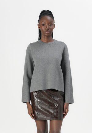 Grå genser med lange ermer og rund hals, parret med et brunt skinnskjørt med krokodillemønster, med en noe kort design.
