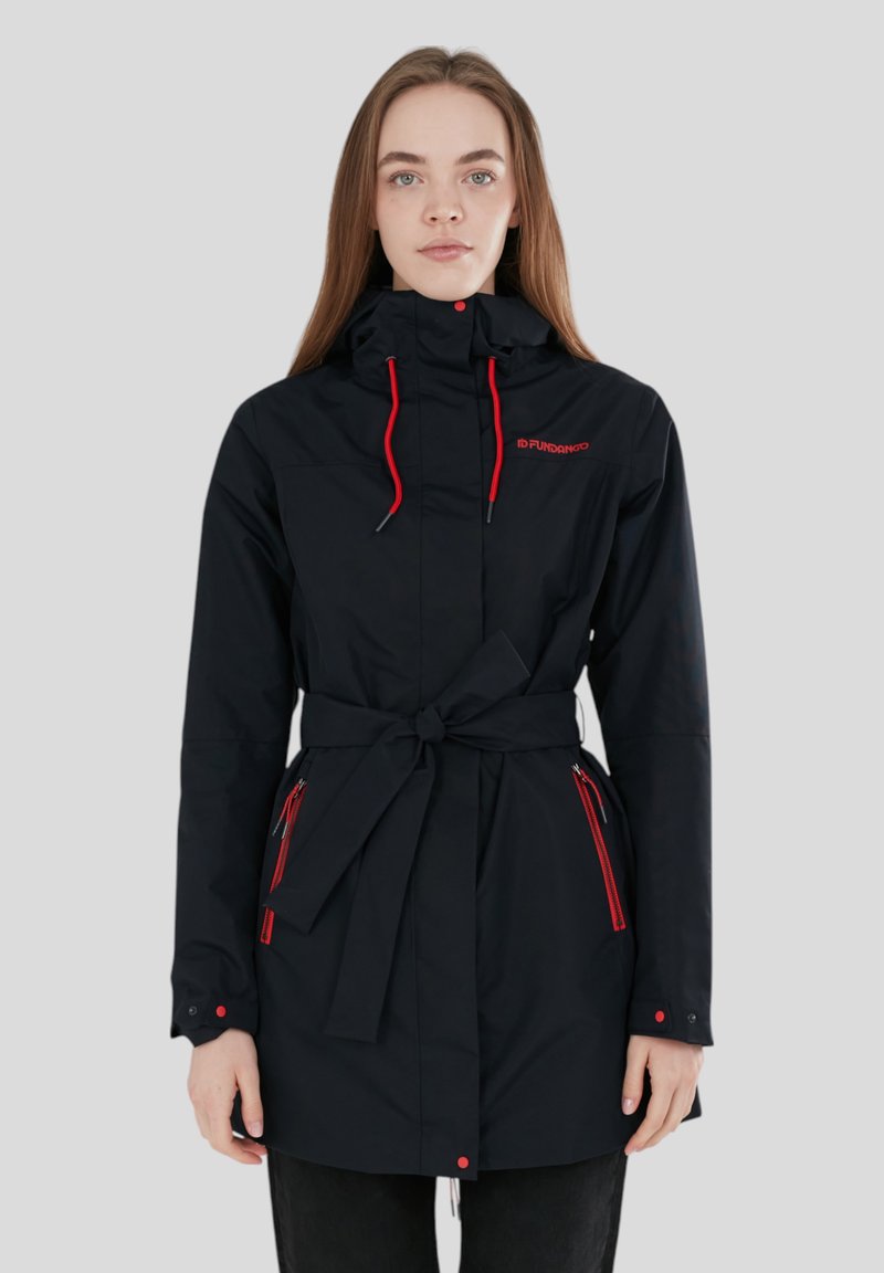 Giacca nera impermeabile con vita cinchata, accenti rossi, cappuccio e tasche con zip. Realizzata in tessuto liscio e resistente alle intemperie.