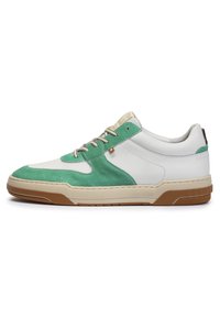 Sneaker con superiore in pelle bianca e suede verde, punta testurizzata, intercala beige e suola in gomma marrone. Presenta lacci piatti e etichetta con logo.