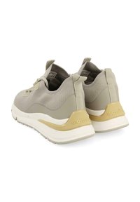 Zapatillas deportivas de color gris claro con un upper de punto texturizado, acentos en color beige, tirador en el talón y suela de amortiguación blanca.
