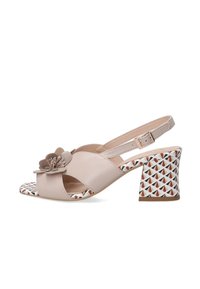 Beige faux leren slingback sandaal met een bloemaccent, open teen en een gepatternde blokhak met driehoeken in rood en zwart.