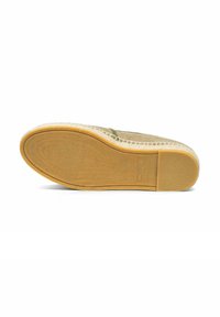 Zool van een beige espadrille-schoen met een geweven juten middenzool en rubberen buitenzool, getoond van onderaf op een witte achtergrond.