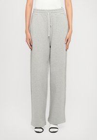Grå sweatpants lavet af blødt stof med en elastisk talje og snore. Bred ben-design og sidelommer. Glat tekstur og minimale syninger.