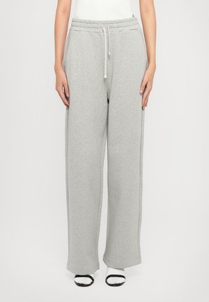 Grå joggebukser laget av myk stoff med snor i livet, bred ben-design og sidelommer. Glatt tekstur og minimale sømdetaljer.