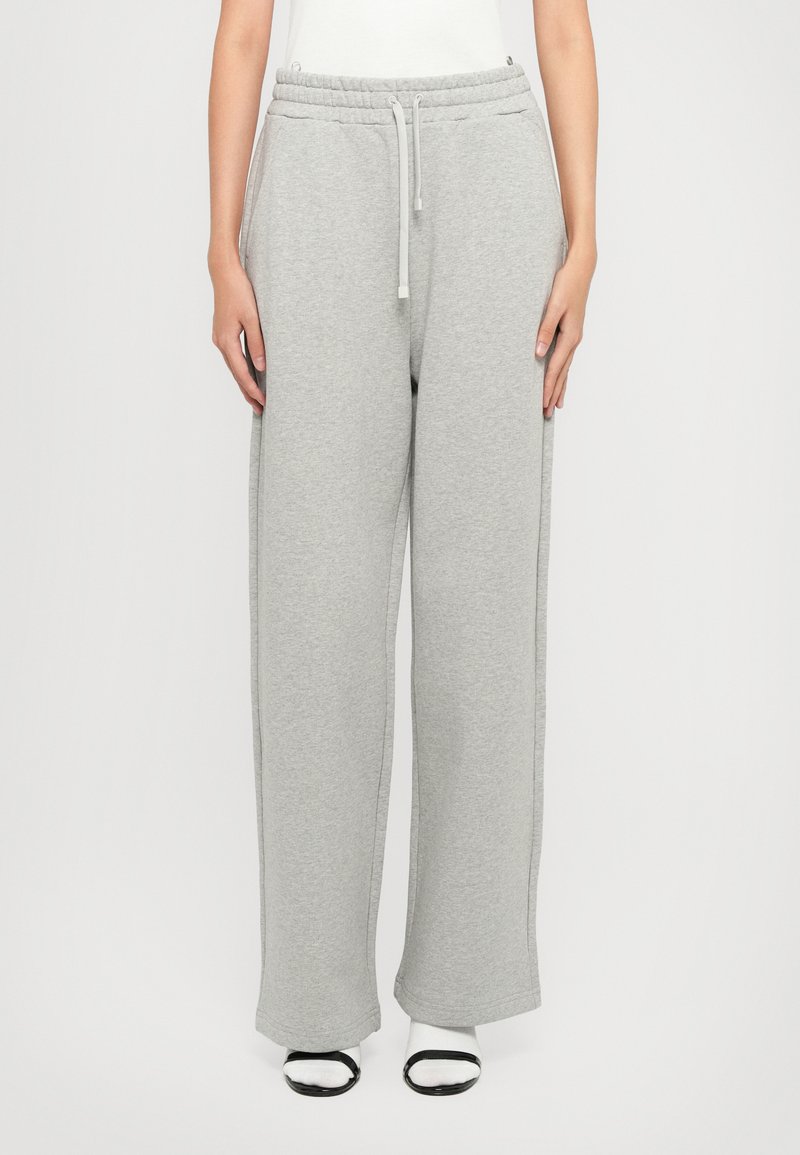 Grå sweatpants lavet af blødt stof med en elastisk talje og snore. Bred ben-design og sidelommer. Glat tekstur og minimale syninger.