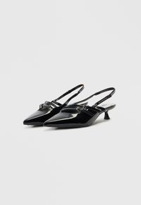 Μαύρα παπούτσια slingback από δερμάτινο λουστρίνι με μυτερή μύτη, χαμηλό τακούνι και δύο μπροστινές λουρίδες με μικρές μεταλλικές λεπτομέρειες.