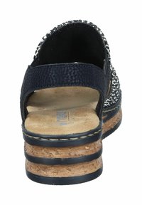 Black and white textured sandal with cork platform heel, wide strap, and soft footbed. Rear view highlights the curved heel and stitching details.