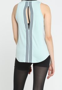 Top atletico senza maniche di colore blu chiaro, con un'apertura a forma di chiave e strisce nere verticali lungo la schiena, realizzato in un tessuto morbido ed elastico.