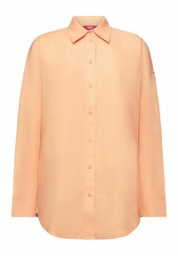 Chemise à manches longues de couleur pêche avec col, boutons cachés et un ourlet légèrement arrondi.