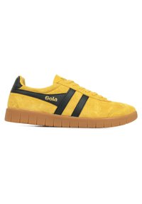 Geel suède sneaker met zwarte leren accenten en twee zwarte strepen. Heeft een gestructureerde zool en het "Gola" logo in goud.