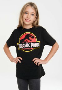 Black cotton t-shirt featuring a red and yellow Jurassic Park graphic with a dinosaur silhouette. Short sleeves, relaxed fit.
