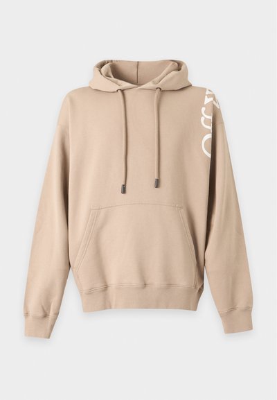Sweat à capuche beige avec poche avant, cordons et texte blanc partiel sur la manche droite à l'épaule sur un fond uni.
