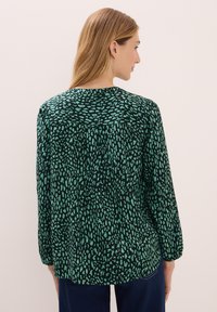 Groene blouse met een geprinte textuur van verschillende vormen, lange mouwen en een ronde halslijn, geschikt voor casual gebruik.