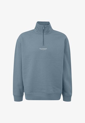 Jasnoniebieska bluza z wysokim kołnierzem i częściowym zamkiem. Na piersi znajduje się biały napis logo. Miękka tkanina, ściągacze na mankietach i dolnym brzegu.