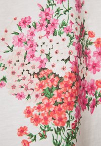 Tela con estampado floral que presenta flores rosas y naranjas sobre un fondo blanco. Incluye hojas verdes y un detallado intrincado en el patrón.